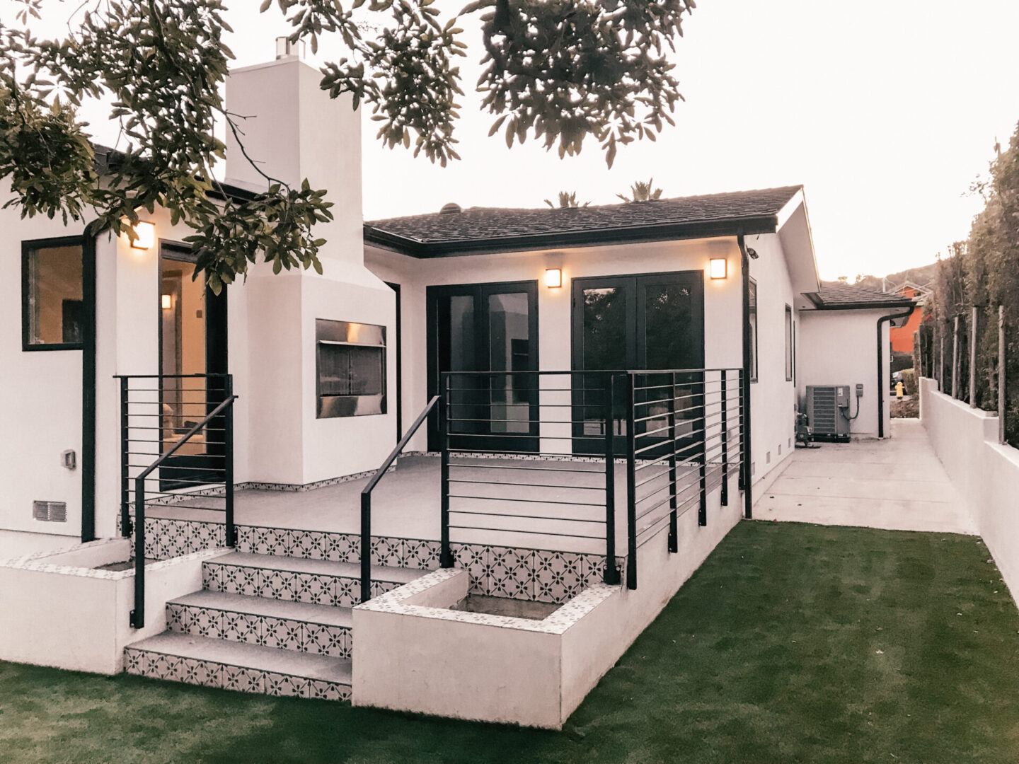 A white house with black railing and steps.