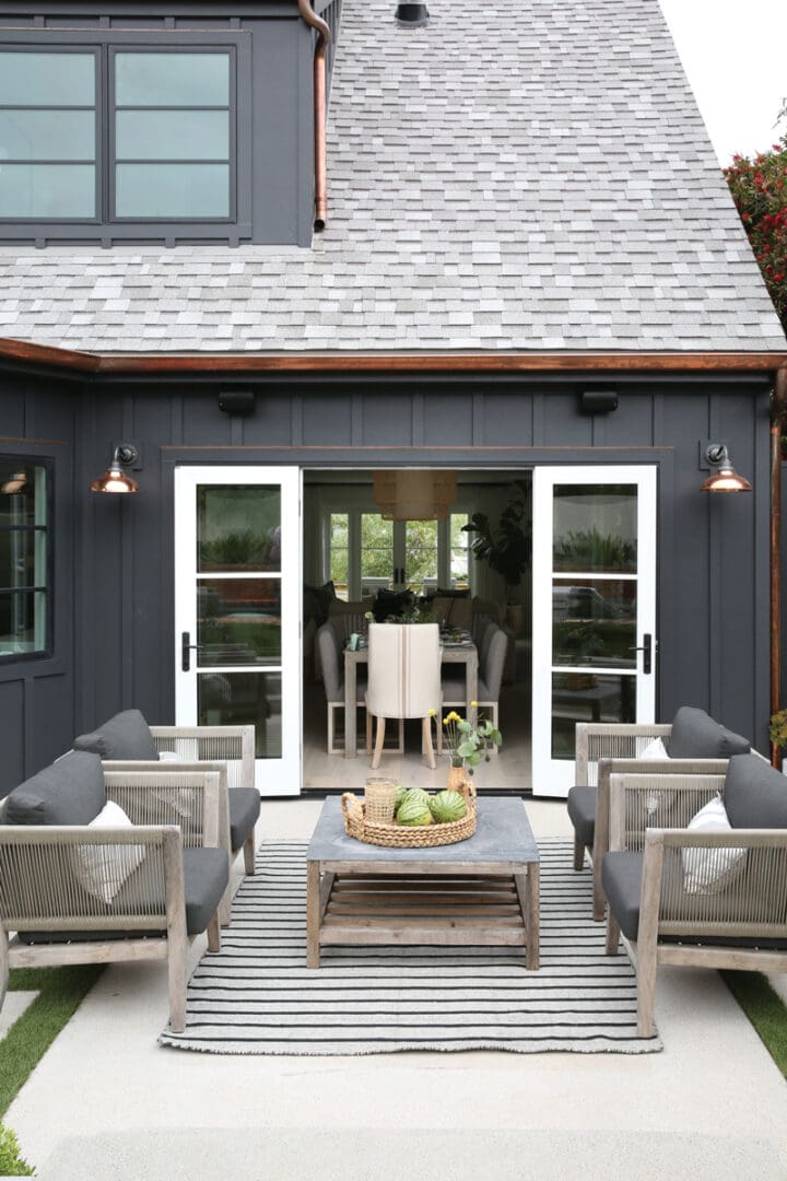 A patio with chairs and tables outside of it